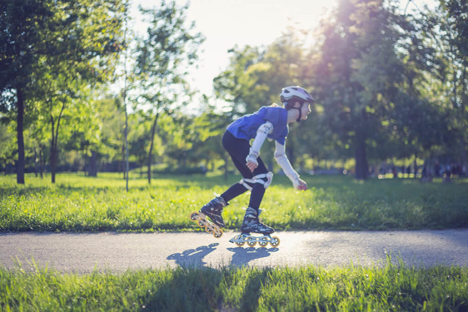 Junge mit Rollschuhe im Park